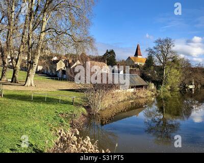 Blick über den Fluss Claise zu Preuilly-sur-Claise und die Abteikirche - Indre-et-Loire, Frankreich. Stockfoto