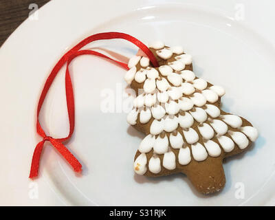 Weihnachtsbaum Lebkuchen cookie Ornament aus der Ukraine mit rotem Band zum Aufhängen am Weihnachtsbaum. Stockfoto