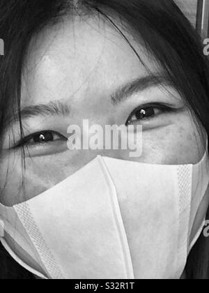 Eine junge Chinesin, die eine Maske trägt. Stockfoto