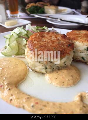 Gourmet-Entrée mit großen Krabbenkuchen mit Gurkensalat und roter Paprikaschremulade, USA Stockfoto