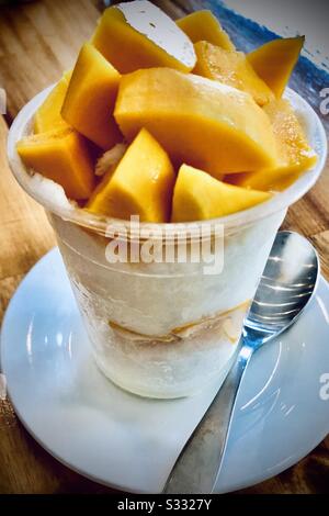 Bingsu (Koreanisch rasierte Eis) Tasse mit frisch geschnittenem Mango-Belag, serviert in Siem Reap, Kambodscha Stockfoto