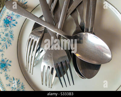 Gabeln und Löffel auf einer Platte Stockfoto