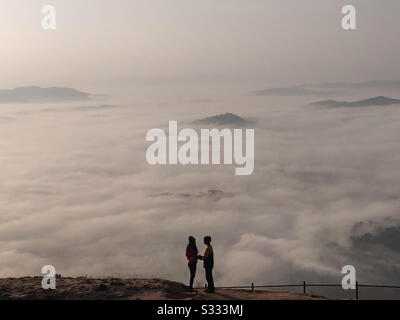 Wunderschönes Paar auf der Spitze des Berges pft gerne mit Wolken Stockfoto