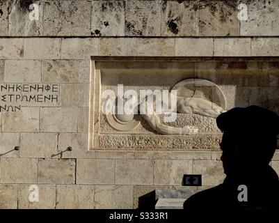 Silhouette eines griechischen Soldaten, der in Dienst am Grab des Unbekannten Soldaten (1932) auf dem Syntagma-Platz in Athen, Griechenland steht. Dieses Grabmal im Art-Deco-Stil liegt vor dem griechischen Parlament. Stockfoto