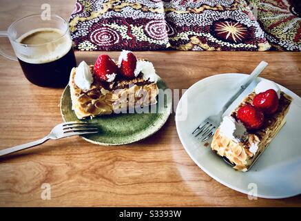 Zwei Stücke Napoleon Kuchen und eine Tasse schwarzen Kaffee auf einem Holztisch Stockfoto