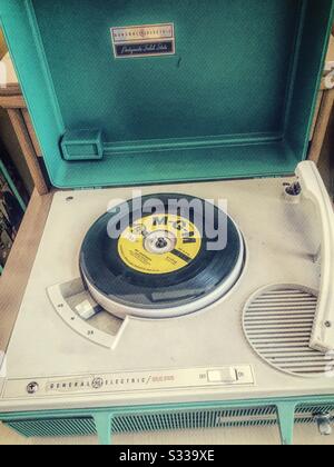 Tragbarer Phonographiespieler aus den 1960er Jahren mit einer Schallplatte aus Vinyl, 45 U/min, darauf, USA Stockfoto