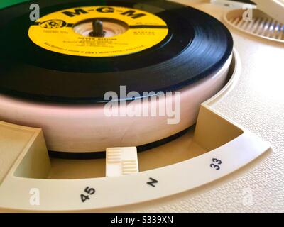 Vinyl-Schallplatte mit 45 U/min auf einem tragbaren Phonographen-Player der 1960er Jahre, USA Stockfoto