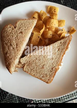 Flat Lay of Thunfisch Sandwich auf Vollweizenbrot und Maisspäne Mittagessen Stockfoto