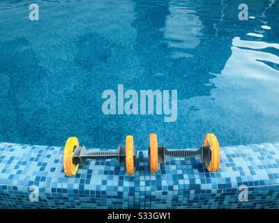 Gewichte am Poolrand Stockfoto