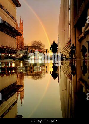 Wetter in Großbritannien: Ein Regenbogen scheint über das Walkie-Talkie-Gebäude, wie es sich auf einer verregneten Straße im Holborn Viaduct, London, England widerspiegelt. Stockfoto