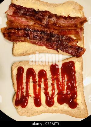 Speck auf braunem gebuttertem Brot mit Tomatenketchup, offenes Frühstückssandwich Stockfoto