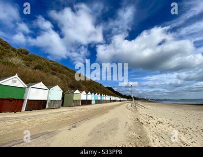 Eine Reihe von Strandhütten an der Promenade von Bournemouth im Winter mit einem tollen Himmel, Großbritannien. Stockfoto