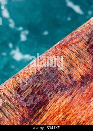 Ein Detail einer verwitterten Holzboot-Deck-Schiene. Stockfoto