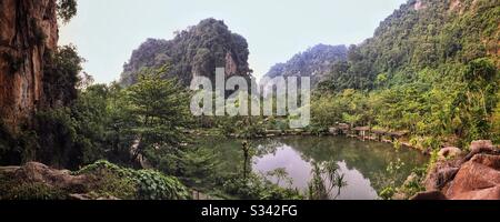 Der Blick von der SkyBar im Banjaran Hotsprings Retreat, mit Blick auf einen künstlich anfertigen See, der von Erdwärmekochquellen gespeist wird, und die spektakuläre Kalkkarstlandschaft in der Nähe von Ipoh, Malaysia Stockfoto