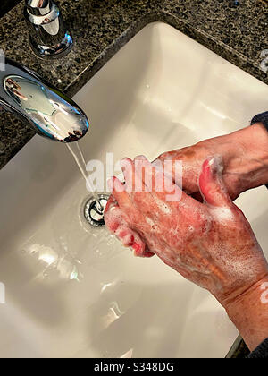 Frau wäscht ihre Hände in einem Waschbecken Stockfoto