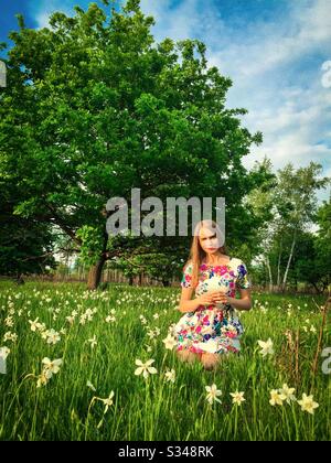 Junge Frau auf einem Feld von Narzissen Stockfoto