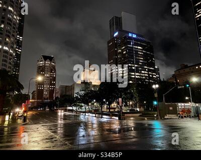 LOS ANGELES, CA, MAR 2020: Weitblick LA Public Library, Central Branch in Downtown mit nahe gelegenen Wolkenkratzern dahinter. Nasse Straßen von Regen reflektieren die Lichter der Stadt in der Nähe Stockfoto