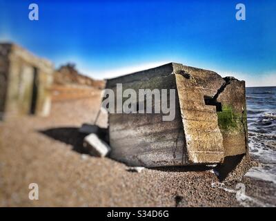 Kriegsschutz am Strand aufgrund der Auswirkungen der Küstenerosion, Bawdsey, Suffolk, England. Stockfoto