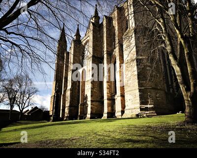 Architektur von Durham City, North East England. Gotische Architekturdetails der Durham Cathedral mit steinernen Strebepfeilern und Rosettenfenster Stockfoto