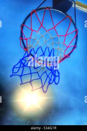 Basketballkorb und Sonne gegen blauen Himmel Stockfoto