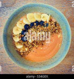 Mango-Smoothie mit Granola, Bananen und Blaubeeren Stockfoto