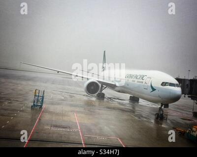 Eine Boeing 777 der Cathay Pacific Airways auf dem Vorfeld bei starkem Regen auf dem internationalen Flughafen Hongkong Stockfoto