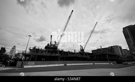 LOS ANGELES, CA, MAR 2020: Silhouettenkräne, die am Bau des neuen, von Frank Gehry entworfenen Gebäudes arbeiten, gegenüber der Walt Disney Concert Hall in der Innenstadt. Schwarz und Weiß Stockfoto