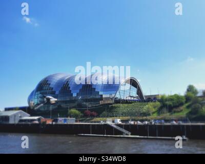 Architektur von Newcastle Quayside unter einem blauen Sommerhimmel. Newcastle upon Tyne, North East England. Die sage Gateshead am Fluss Tyne. Modernes futuristisches Glasgebäude Stockfoto