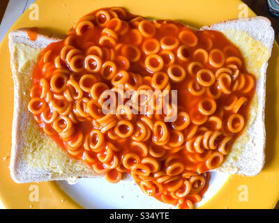 Spaghetti klingelt in Tomatensauce auf gebuttertem Toast. Stockfoto