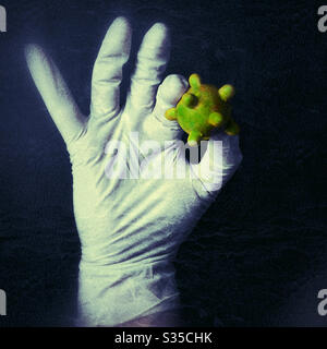 Die Hand mit Latexhandschuhen hält ein übergroßes COVID-19 Coronavirus Stockfoto