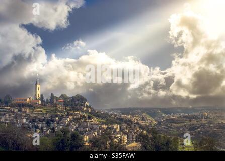 Licht baut den Turm der Himmelfahrt auf dem Ölberg in Jerusalem. Die Tradition sagt, dass Jesus von diesem Punkt in den Himmel aufgestiegen ist. Am Fuße des Berges die Altstadt von Jerusalem. Stockfoto