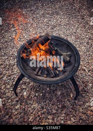 Großes Feuer in einer Feuerstelle, auf Kies. Stockfoto