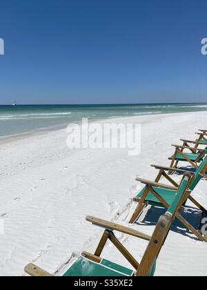 Farbenfroh grüne Liegestühle am weißen Sandstrand mit Blick auf das smaragdgrüne Wasser des Golfs von Mexiko Florida Stockfoto