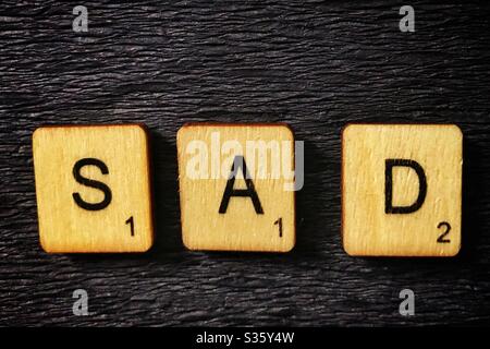 Holzfliesen buchstabieren Sad. Stockfoto