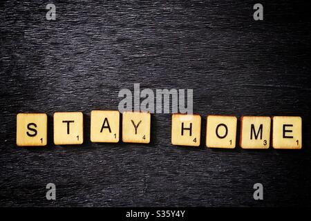 Holzfliesen buchstabieren Stay Home. Stockfoto