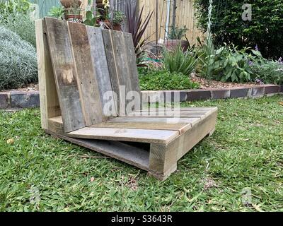 Ein Covid-19 Coronavirus-Heimprojekt, ein handgebauter Gartensitz, der aus alten, hochgetaktenen Holzzäunungsmaterialien gefertigt wurde Stockfoto