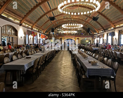 München, 23. Juni 2017: Das Hofbräuhaus München ist im Inneren des Festsaals zu sehen, wo Gäste speisen und eine Band auf der Rückseite des Raumes spielt. Stockfoto