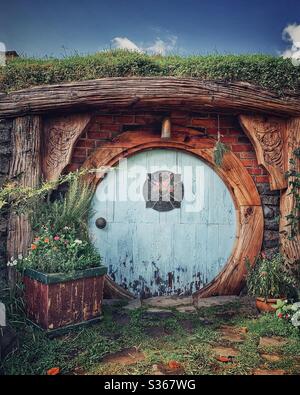 Hobbiton. Bukolischer Ort in Neuseeland, wo die Hobbits aus der Mittelerde leben. Lord of the rings Filmset. Blaue runde Tür Stockfoto