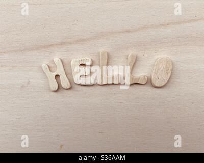 Hello Text mit handgefertigten Holzbuchstaben auf einem Holzbrett komponiert Stockfoto