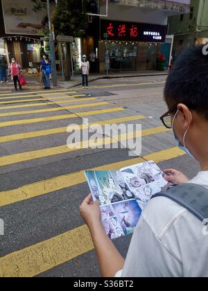 Manga beim Gehen lesen. Stockfoto