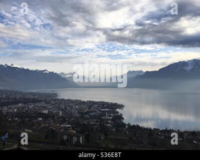 Blick hinunter auf den Genfer See in der Schweiz. Im Bild ist die Stadt Vevey und die Schweizer Alpen in der Ferne einschließlich Les Dents Du Midi, der höchste Gipfel der Schweiz. Stockfoto