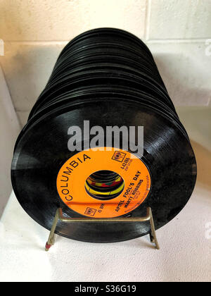 Plattenregal mit einer Gruppe von Vintage-Black-Schallplatten mit 45 U/min Stockfoto