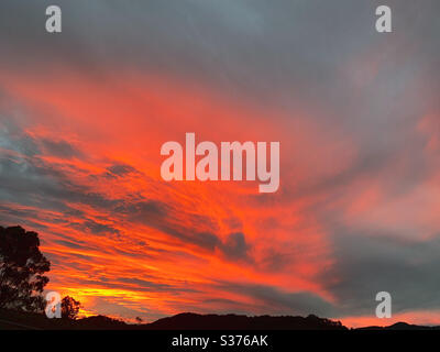 Dramatischer Sonnenuntergang an einem australischen Winterabend, der wie der Himmel auf Feuer aussieht, ist Mutter Natur von ihrer spektakulären Bestform Stockfoto