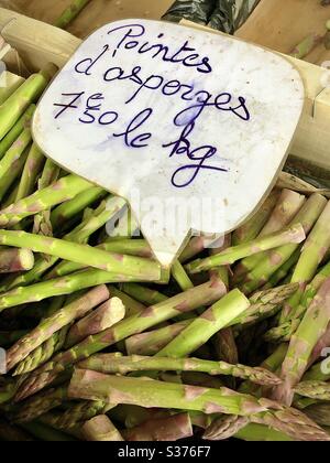 Frische junge Speere mit violett gefärbtem grünen Spargel am französischen Marktstand. Stockfoto