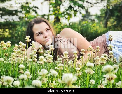 Teenager-Mädchen liegt in Kleeblatt Patch Stockfoto