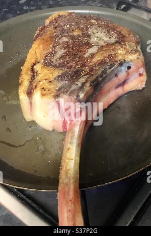 Gewürztes Tomahawk Steak in einer Pfanne Stockfoto