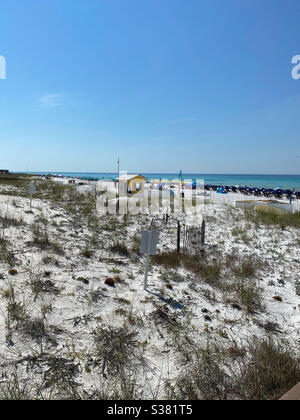 Blick auf den weißen Sand Florida Strand mit Sonnenschirmen und Menschen genießen einen Sommertag am Strand Stockfoto