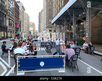 Essen im Freien nur in New York City während der Coronavirus Pandemie Sperre. New Yorker genießen die Möglichkeit, im Restaurant La Pecora Bianca zu essen. Straße geschlossen für Tisch im Freien aufgestellt Stockfoto