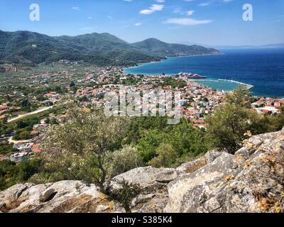 Blick auf die Hauptstadt der Insel Limenas mit Olivenbäumen vor und grünen Bergen dahinter. Stockfoto