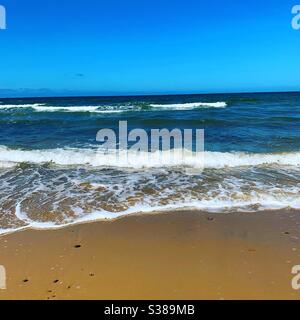 Wellen am Cromer Beach, an einem warmen sonnigen Tag im Juli. Cromer, Norfolk, Großbritannien. Stockfoto